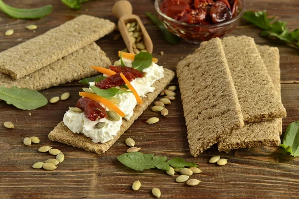 Pan crujiente con queso crema, tomates secados al sol y hierbas —  Fotos de Stock