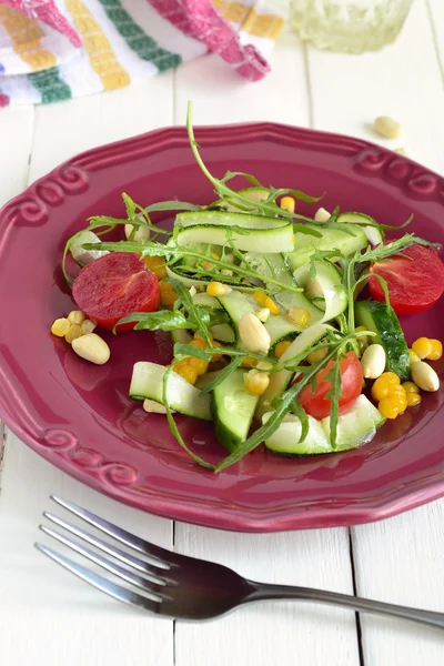 Свежий салат с цуккини, рукколой, кукурузой, огурцами и помидорами — стоковое фото