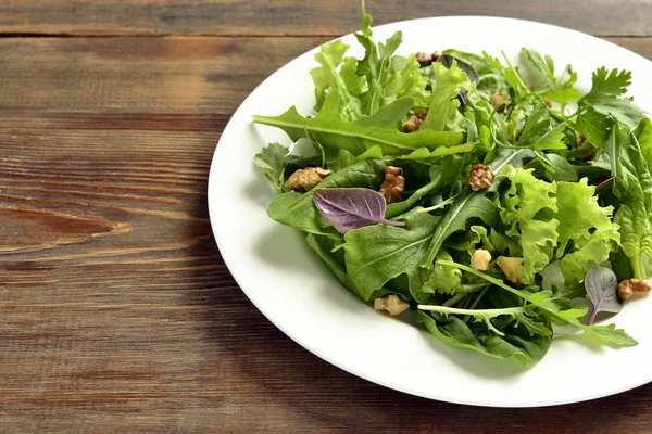 Свежий зеленый салат со шпинатом, рукколой, салатом, травами и орехами Стоковое Фото