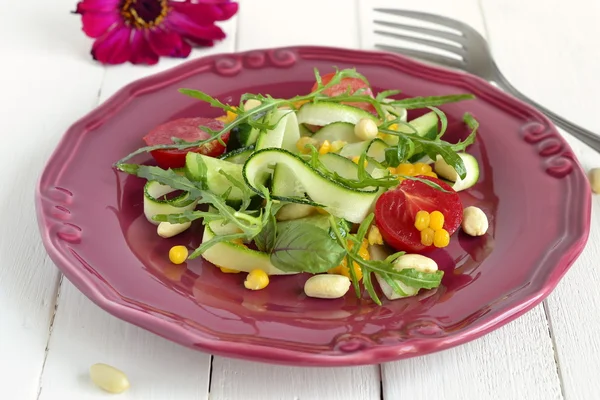 Fresh salad with zucchini, arugula, corn, cucumbers and tomatoes — Stock Photo, Image