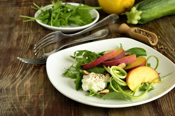 Salad with arugula, zucchini, peaches and yogurt — Stock Photo, Image