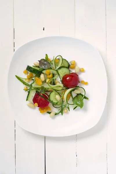 Свежий салат с цуккини, рукколой, кукурузой, огурцами и помидорами — стоковое фото