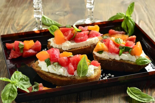 Italian bruschetta with chopped tomatoes, basil and cheese on crusty bread — Stock Photo, Image