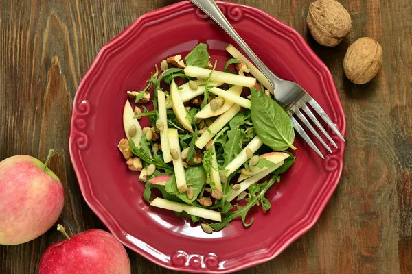 Салат из яблок с грецкими орехами, тыквенными семечками и рукколой — стоковое фото