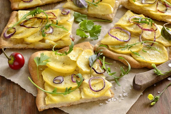 Vejetaryen pizza patates, kırmızı soğan ve yeşillik ile