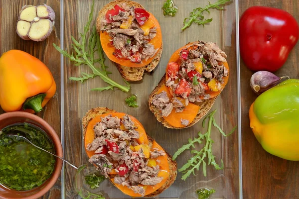 Bruschetta with tuna, tomatoes and sweet peppers with sauce — Stock Photo, Image