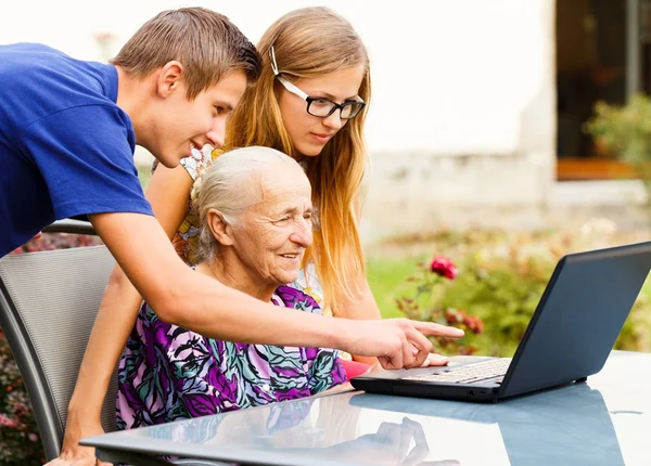 Wnuk pomaga babcia z nowoczesną technologią — Zdjęcie stockowe