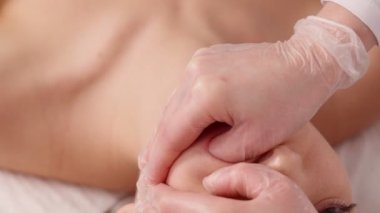 Kozmetolog hastaların yüz kasları bir bukkal masaj yapar.