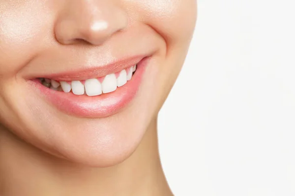 Όμορφη νεαρή γυναίκα με υγιή δόντια σε λευκό φόντο. — Φωτογραφία Αρχείου
