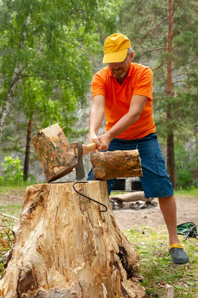 Человек рубит дрова топором для костра в походе. — стоковое фото