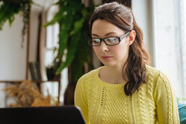 Evde dizüstü bilgisayarda çalışan bir kadın, serbest çalışan biri.