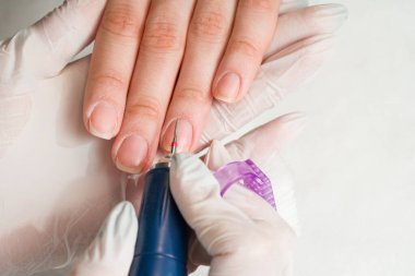 Tırnak törpüsü takan bir güzellik uzmanı manikür yaptırıyor. Güzellik ve el bakımı..