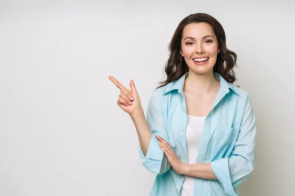 Mujer joven sonriendo y haciendo gestos para copiar espacio. —  Fotos de Stock