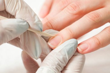 Tırnak törpüsü takan bir güzellik uzmanı manikür yaptırıyor. Güzellik ve el bakımı..