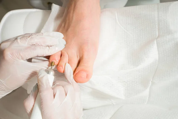 Un podiatre qui s'occupe des ongles d'une femme. Procédures cosmétiques des pieds — Photo