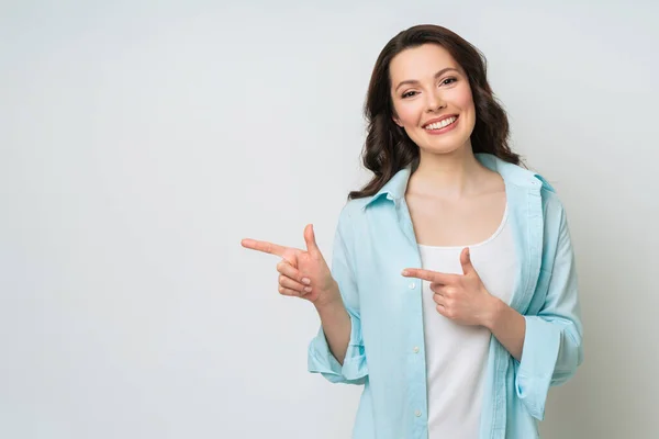 Mujer joven sonriendo y haciendo gestos para copiar espacio. —  Fotos de Stock