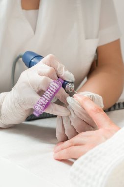 Tırnak törpüsü takan bir güzellik uzmanı manikür yaptırıyor. Güzellik ve el bakımı..