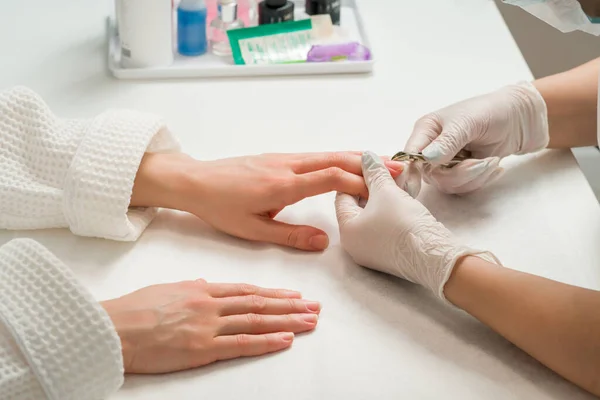 Femme dans un salon de manucure recevant une manucure par un esthéticienne avec lime à ongles. Beauté et soin des mains close-up. — Photo