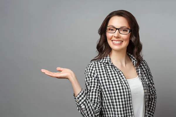 Jovem mulher sorrindo e gesticulando para copiar o espaço. — Fotografia de Stock