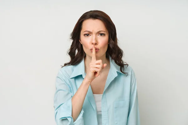 Young brunette shows the silence gesture — Stock fotografie