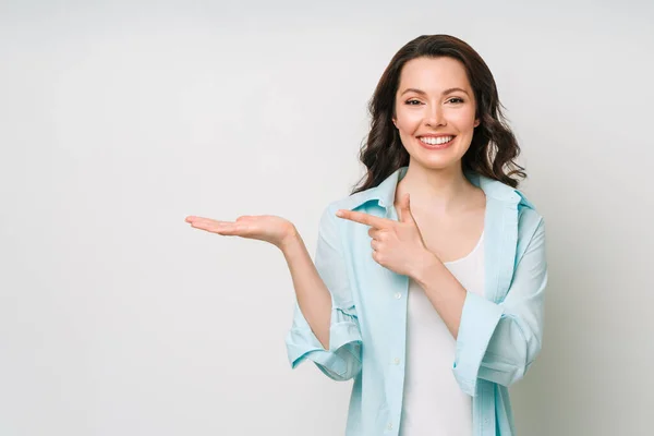 Mujer joven sonriendo y haciendo gestos para copiar espacio. —  Fotos de Stock