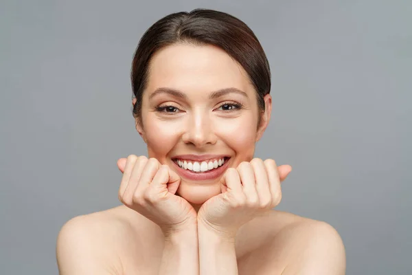 Joven mujer hermosa con la piel perfecta, tocando su cara y sonrisa. Cosmetología, belleza y concepto de spa. — Foto de Stock