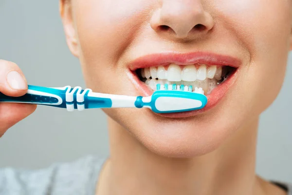 Žena se zdravými bílými zuby drží kartáček na zuby a usmívá se. Ústní, hygienický koncept — Stock fotografie