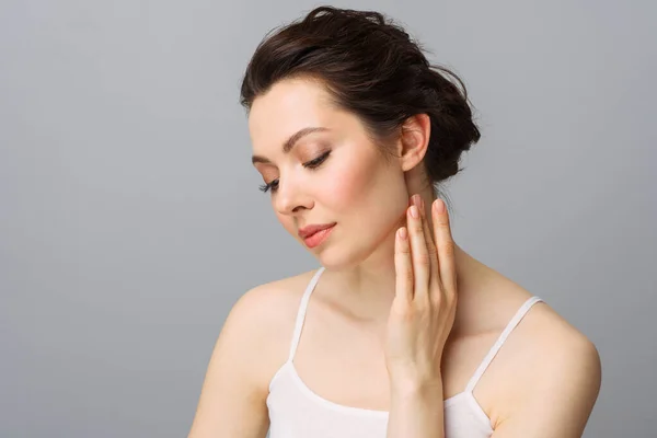 Jonge mooie vrouw met een perfecte huid, die haar gezicht aanraakt. Cosmetologie, schoonheid en spa concept. — Stockfoto