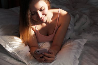 Genç ve çekici bir sarışın akıllı telefonuna bakar ve gülümser. Kız telefonda hoş bir yazışma yapıyor. Kız para transferiyle ilgili bir mesaj almış..