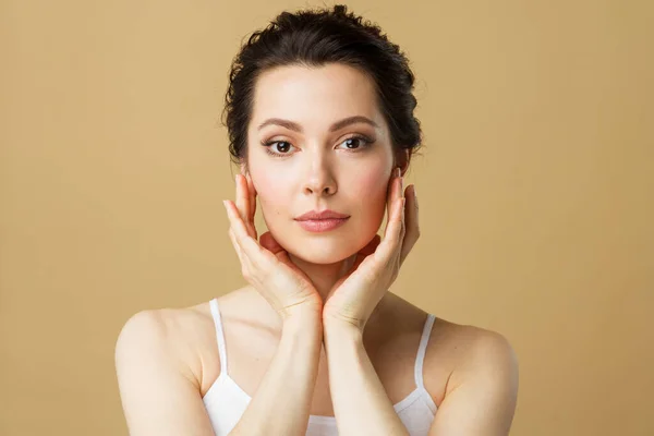 Jonge mooie vrouw met een perfecte huid, die haar gezicht aanraakt. Cosmetologie, schoonheid en spa concept. vrouwelijk schoonheid model. — Stockfoto