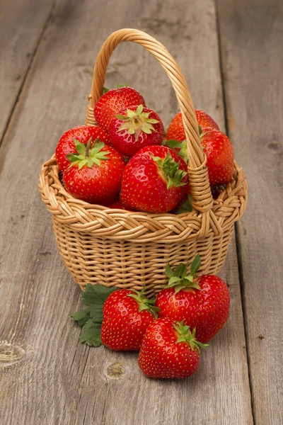 Erdbeeren im Korb auf einem Holztisch — Stockfoto