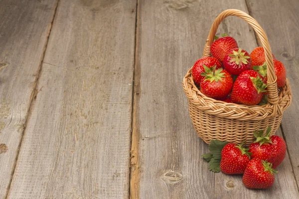 Erdbeeren im Korb auf einem Holztisch — Stockfoto