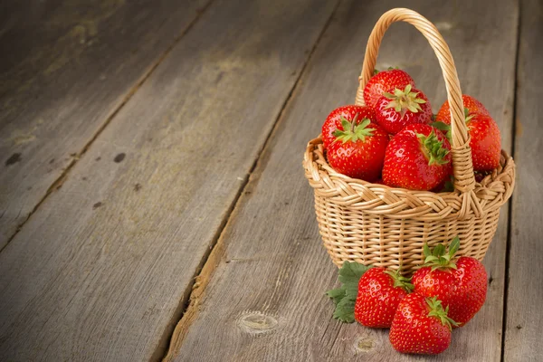 Erdbeeren im Korb auf einem Holztisch — Stockfoto