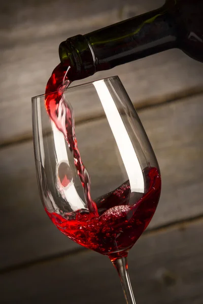 Бутылка, наполняющая бокал вина — стоковое фото