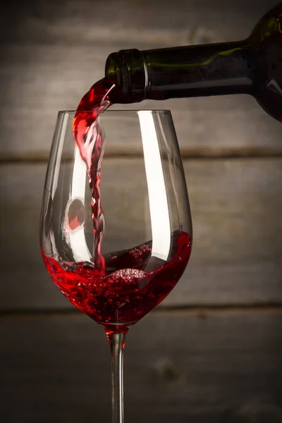 Бутылка, наполняющая бокал вина Стоковая Картинка