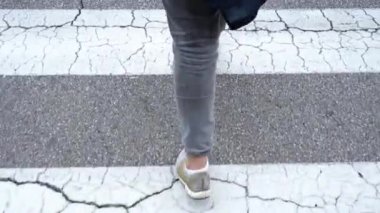 Yaya geçidinde asfalt üzerinde beyaz çizgiler var.