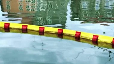 Çubuğu bölen ince kırmızı ve sarı su suyun üzerinde yatıyor.