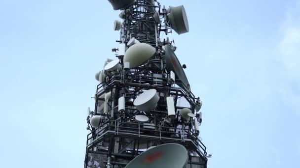 Vysoká kovová věž s velkými a malými satelitními anténami — Stock video
