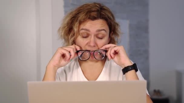 Депресивний фрілансер гризе окуляри, що сидять на ноутбуці — стокове відео