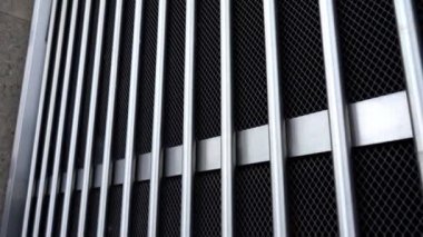 Büyük kafes ve parlak metal matt dikey çubuklu kapı