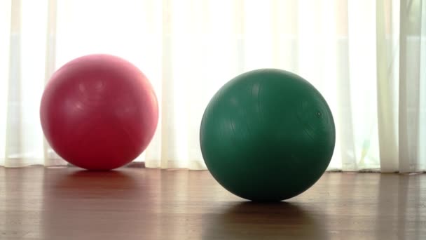 Balles d'exercice de couleurs rose et turquoise sur sol en bois — Video