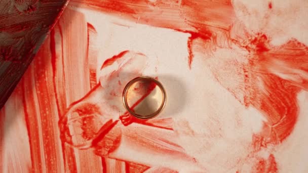 Goldener Ring liegt auf weißem Tisch neben silbernem Messer mit Blut — Stockvideo