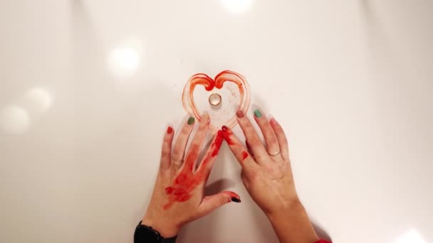 Жіночі пальці, заплямовані кров'ю, рухаються навколо золотого кільця — стокове відео