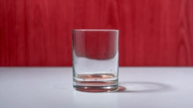 Beyaz masada duran şeffaf camlar sıvıyla dolu.
