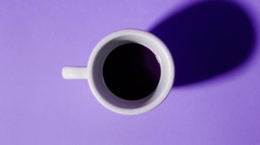 Beyaz porselen bardaklar doldurulur ve siyah kahveyle boşaltılır.