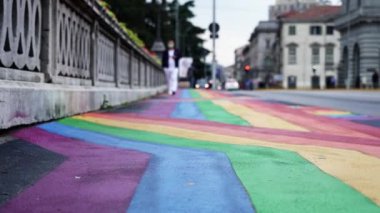 Bright rainbow flag stripes depicted on wide sidewalk