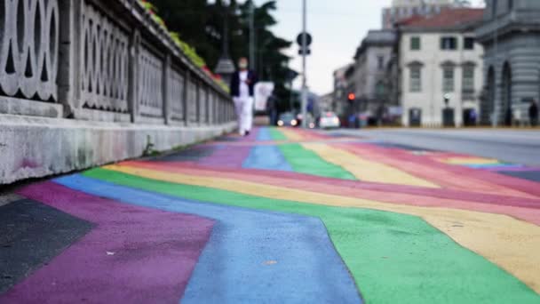 Bright rainbow flag stripes depicted on wide sidewalk — Stockvideo