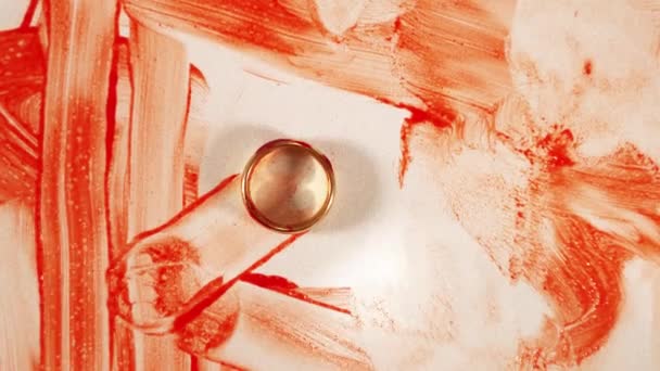 Anillo de oro se encuentra entre manchas de sangre que proyectan sombra sobre la mesa — Vídeo de stock