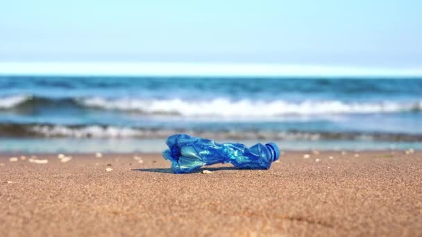 皱巴巴的蓝色塑料瓶落在沙滩上 — 图库视频影像