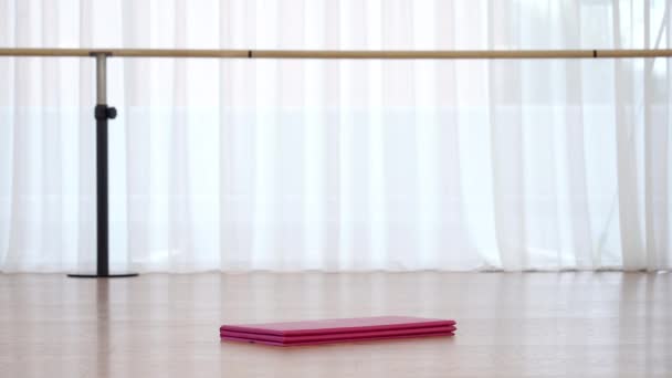 Roze en grijze rolmatten verschijnen in grote stapel op bruine vloer — Stockvideo